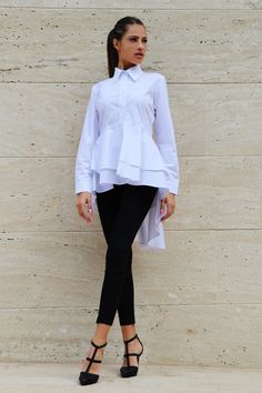 Embrace extravagant elegance with our white asymmetric long sleeve formal shirt. This unique piece features an asymmetrical tunic design that adds a touch of artistic flair to your ensemble. Ideal for formal occasions, it's a statement-making choice for those who appreciate distinctive style. Features: 🤍 Crisp White Elegance 👚 Asymmetric Long Sleeve Tunic ✨ Perfect for Formal Events 🌟 Ideal for Those Who Appreciate Unique Style Order now for a distinctive and stylish addition to your formalwe Elegant Peplum Blouse For Fall, Fitted Asymmetrical Blouse For Daywear, Elegant Asymmetrical Top With Ruffles, Elegant Asymmetrical Ruffled Tops, Fitted Asymmetrical Office Blouse, Elegant Asymmetrical Hem Tops For Work, Formal Spring Blouse With Asymmetrical Hem, Elegant Office Blouse With Asymmetrical Hem, Elegant Asymmetrical Tops For Daywear