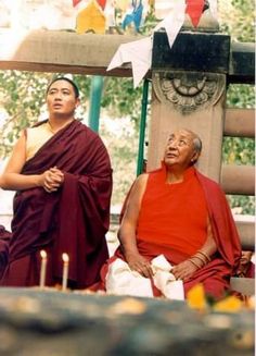 two men sitting next to each other with candles in front of them