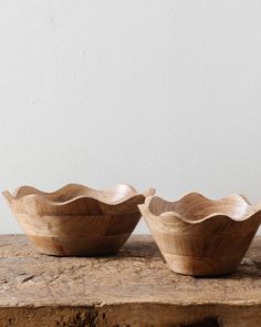 two wooden bowls sitting on top of a table