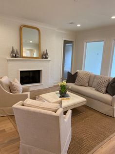 a living room with couches, chairs and a fire place in the fireplace area