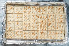 crackers are placed on top of tin foil in a baking pan, ready to be baked