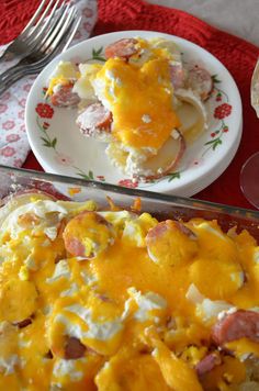 a casserole dish with ham and cheese on it, next to a plate of food