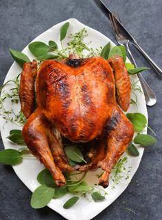 a whole chicken on a plate with leaves