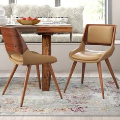 two green chairs sitting at a wooden table