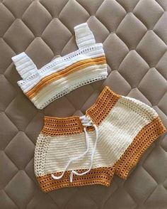 two crocheted swimsuits sitting on top of a bed next to each other