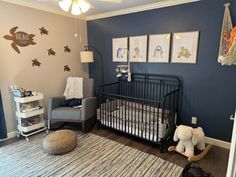 a baby's room is decorated in blue and gray with pictures on the wall