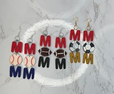 the letter m is for football, soccer ball, and baseball earrings are made out of acrylic