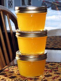 three jars filled with yellow liquid sitting on top of a table