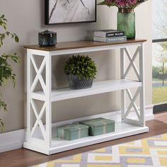 a white shelf with flowers and books on it in front of a large glass window