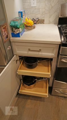 an open drawer in the middle of a kitchen