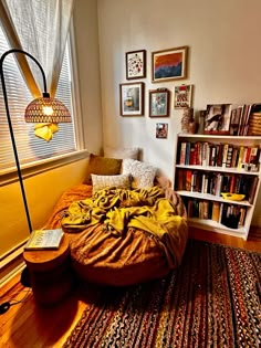 a bedroom with a bed, bookshelf and lamp on the floor in front of it