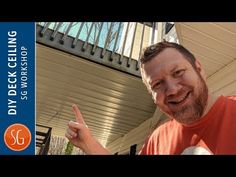 a man is making the peace sign with his hand while standing in front of a porch