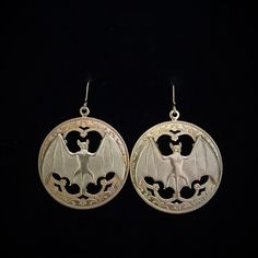 Large Gothic style hoops with a gold brass bat hang from a gold filled French hook earring. The stamped, raw brass hoops have great detail. These are kind of heavy since the 1.25 x .75 inch bats are cast brass. They also have nice detail including eyes, ears, muzzle and hatch marks on the wings. They drop to about 2 inches. Please note that raw brass will oxidize over time, diminishing the brightness and giving it a natural antique darkening of the gold color. This piece of jewelry is sent in a Steampunk Gold Jewelry For Halloween, Gothic Gold Nickel-free Jewelry, Nickel-free Gold Gothic Jewelry, Gothic Gold Brass Earrings, Gold Gothic Brass Earrings, Gothic Brass Earrings Nickel Free, Handmade Gothic Gold Earrings, Handmade Gold Witchy Jewelry, Handmade Witchy Gold Jewelry