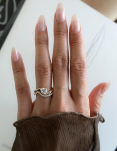 a woman's hand with two wedding rings on top of her left and right hand