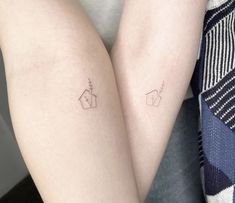 two small tattoos on both legs, one with a house and the other with a flower