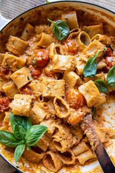 a skillet filled with pasta and spinach