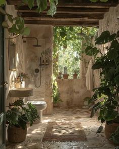 an outdoor bathroom with plants in the shower