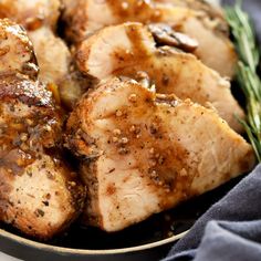 some meat is sitting on a plate with rosemary sprigs