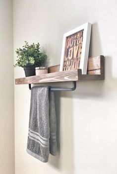 there is a towel rack and potted plant on the shelf in this small bathroom