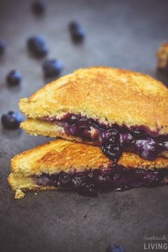 two grilled blueberry sandwiches sitting on top of a table next to fresh blueberries