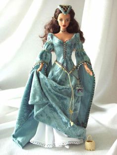 a doll is dressed in a blue gown and tiara