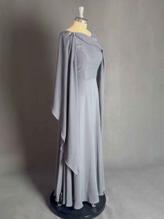 a dress on a mannequin with a cape