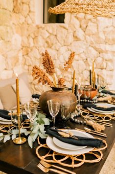 the table is set with black and gold place settings