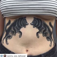 a woman's stomach with tattoos on it and two dogs in the shape of an animal