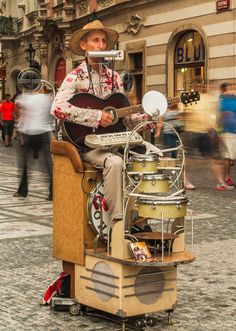 a man sitting on top of a cart holding a guitar