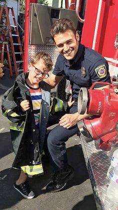 a man and boy standing next to a fire hydrant