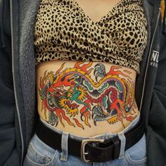 a woman's stomach with tattoos on it and a cheetah print top