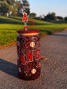 a red and black canister sitting on the side of a road next to grass