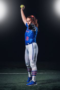 a female baseball player holding a ball in her right hand