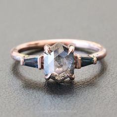 an engagement ring with three stone accents on the side and two blue stones in the middle