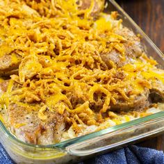 a casserole dish with meat, cheese and onions in it on a wooden table