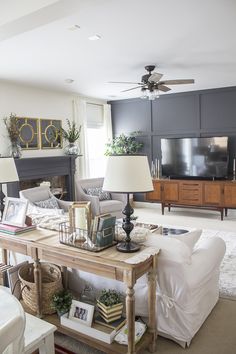 a living room filled with furniture and a flat screen tv on top of a wooden table