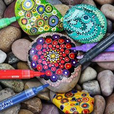 some rocks and pens are laying on the ground next to each other with different designs