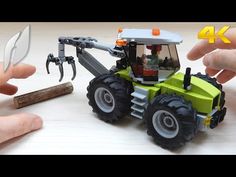 two hands are holding a toy tractor with tools in front of it and another hand is pointing