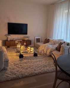 a living room filled with furniture and a flat screen tv mounted to the side of a wall