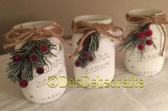 three mason jars with pine branches and berries tied to the lids are sitting on a bed