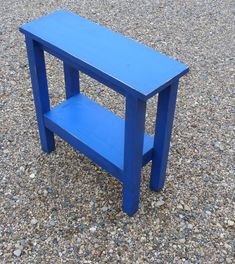 a small blue table sitting on top of gravel