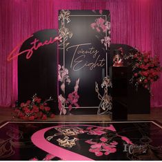 the stage is decorated with pink and black flowers