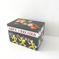 a black box with yellow and red designs on the lid that says, gift record