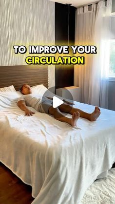 a man laying on top of a white bed in a bedroom