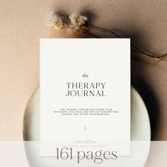 the therapy journal is sitting on top of a white plate with flowers next to it