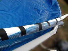 a white and black pipe sticking out of the side of a blue tarp on a boat