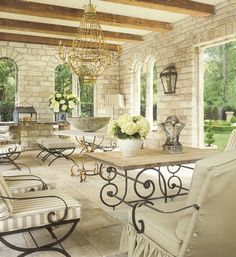 a living room filled with lots of furniture and a chandelier hanging from the ceiling