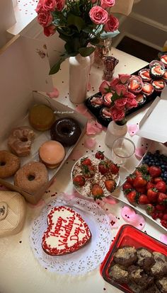 a table topped with lots of cakes and donuts covered in frosted icing