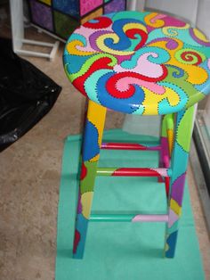 a brightly colored chair sitting on top of a green mat