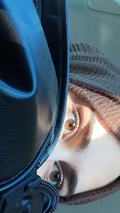 a woman's eyes are reflected in her hat